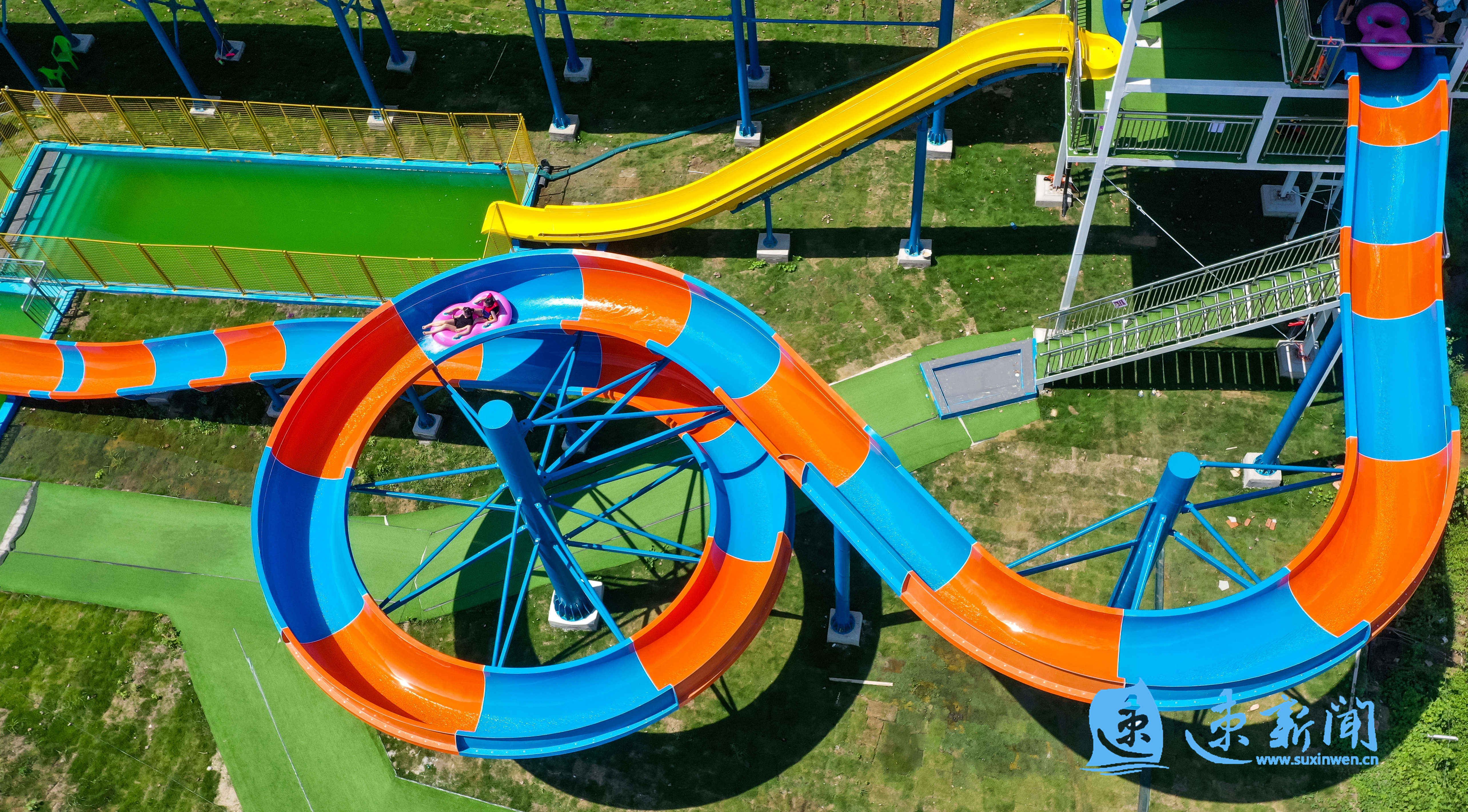 8月14日,在宿迁市泗洪县石集乡的乡村游乐园,家长带着孩子在水上游乐